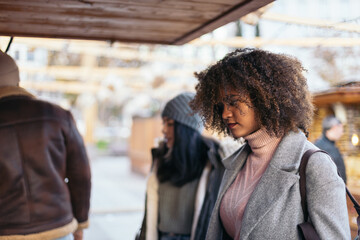 Young woman looking at the stalls of an outdoor market in winter