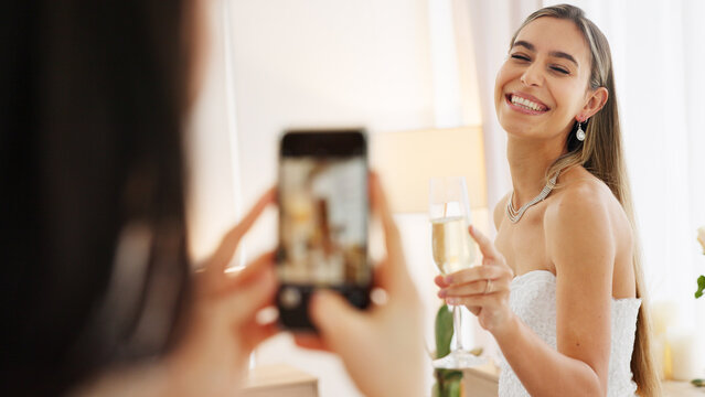 Smartphone photography of bride with champagne glass for wedding celebration to post on social media app. Smile portrait photos or picture taken of woman on digital cellphone and celebrate with wine