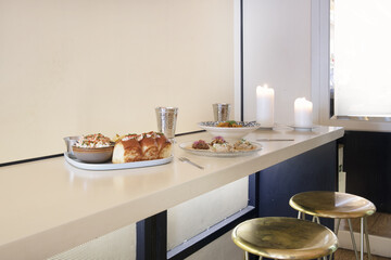 High table of a restaurant with plates of food and stools with golden seat