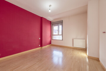 Fototapeta na wymiar empty room with one wall painted red and the rest white, double aluminum window, white radiator and laminate floor