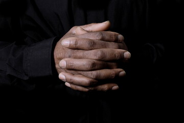 praying to God with hand together on grey black background with people stock photo