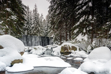 A wild waterfall in Karpacz in the Karkonosze Mountains. Winter landscape of a waterfall in the mountains.