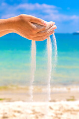 Sand falling through woman hands