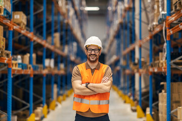 A successful storage manager is standing in delivery center and smiling at the camera.