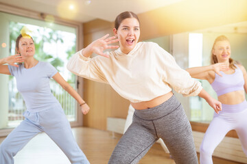 Obraz premium Dynamic young woman attendee of dance studio dancing hip-hop during training session. Women training dance in hall