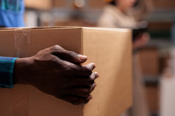 Shipping service warehouse african american man worker holding received parcel in hands. Delivery...