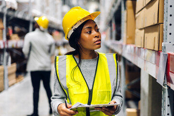 Portrait two african american engineer woman shipping order detail on tablet check goods and supplies on shelves with goods inventory in factory warehouse.logistic industry and business export