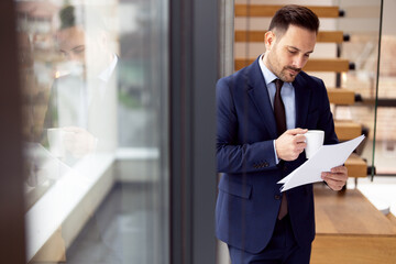 Handsome well dressed businessman holding documents