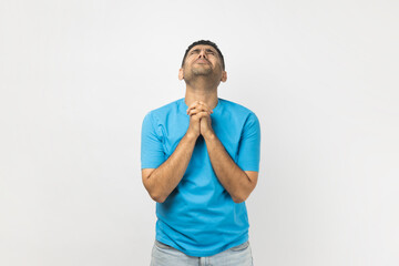Please do me favor for last time. Portrait of unshaven man wearing T- shirt standing presses palms...