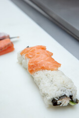A view of a the process of making a sushi roll at an ingredient station of a restaurant.