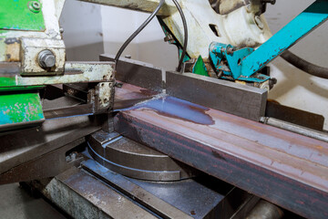Cutting steel profiles and pipes on a band saw in production.