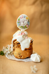 beautifully decorated Easter cake with white cream and decor against the background of branch with flowers
