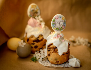 beautifully decorated Easter cake with white cream and decor against the background of a branch with flowers out of focus