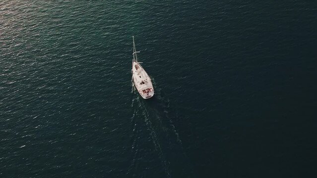 A sailboat on the open sea. minimalist footage. distant camera. bird's eye view. Top above view. Calm scenery of sea. 4k quality