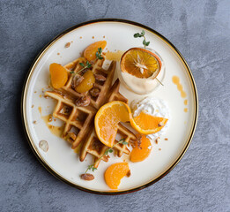 waffles, with berries, nuts & fruit on a gray table, served with ice cream breakfast, no people, horizontal,