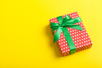 Wrapped christmas or other holiday handmade present in paper with colored ribbon. Present box, decoration of gift on table, top view with copy space