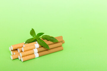 Menthol cigarettes and fresh mint leaves on colored background, Many cigarettes stacked together...