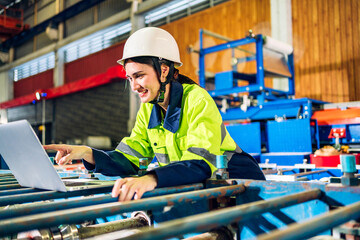 Professional machanic engineer technician industrial man wearing safety uniform working control with laptop on heavy machine in manufacturing  factory production line.business technology robot