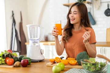 Portrait of beauty body slim healthy asian woman drinking glass of juice and orange.young girl preparing cooking healthy drink with fresh orange juice in kitchen at home.Diet concept.healthy drink