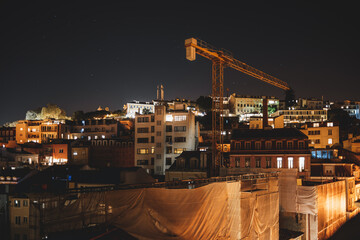 A top-down view of a city under construction at night in low-key and long exposure. Old residential...