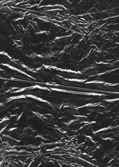 Wrinkled plastic wrap texture on a black background wallpaper.  Royalty high-quality free stock photo image of realistic plastic wrap for overlay, copy space and photo effect. Wrinkled plastic surface