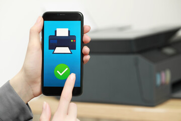 Woman using printer management application on smartphone indoors, closeup and space for text. Image on device screen.