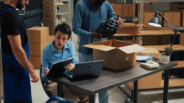 Business owners working on shipping products in warehouse, putting merchandise from shelves in cardboard boxes. Team of partners using goods to work on startup development, supply chain.