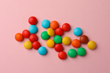 Tasty colorful candies on pink background, flat lay