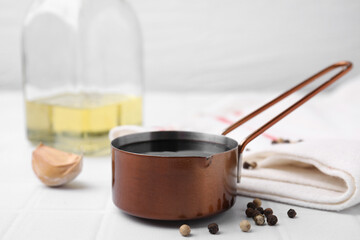 Metal small saucepan with balsamic vinegar and ingredients on white table