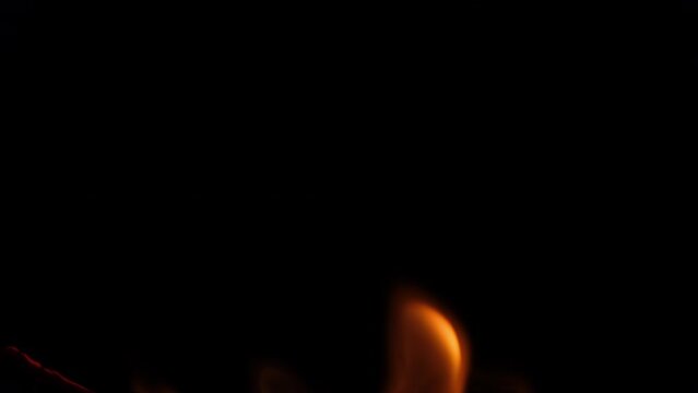 Close-up of burning paper with fire element isolated on black background. flame stream