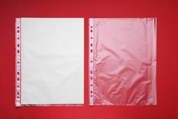 Punched pockets on red background, flat lay. Space for text