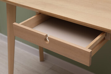 Stylish desk with open empty drawer in office, closeup