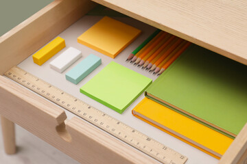 Office supplies in open desk drawer indoors, closeup