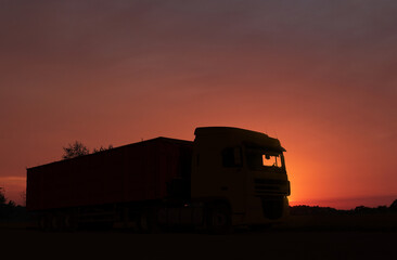 Truck parked on country road at sunset