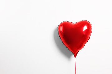 Red heart shaped balloon on white background, space for text