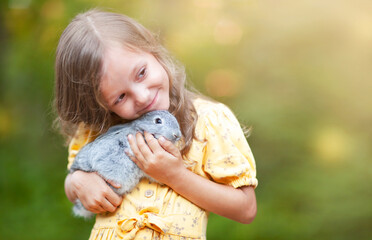 the little girl gently pressed her face against the gray rabbit in her arms
