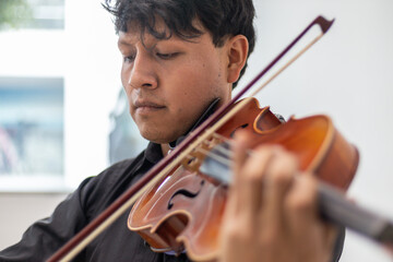 close up of a hand of a hispanic viola player, focus on hand. latin hispanic violin player playing viola or violin