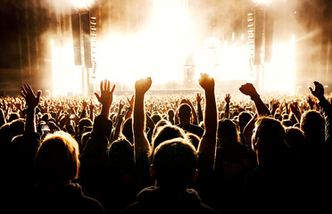 Cheering people crowd on the dance floor during a music concert. - obrazy, fototapety, plakaty