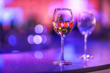 A glass of champagne on the background of lights from the garland. 