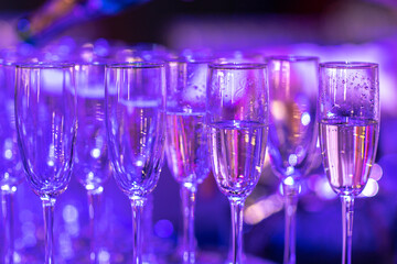 Beautiful line of different coloured cocktails on a Christmas party, tequila, martini, vodka, and others on decorated catering bouquet table . 