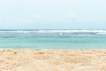 Fototapeta na wymiar Empty sandy beach in the background with a blurry summer sea.