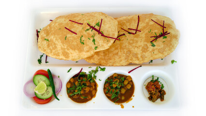 Chole Bhature or Chick pea curry with Fried Puri served in a white ceramic plate