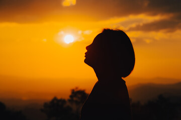 silhouette young woman is looking at the sunset.
