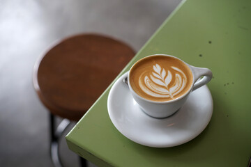 Hot fresh latte coffee on green table background