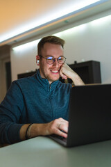 A young man is using his laptop at night for business or studying 