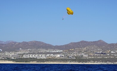 Yellow parachute landing on a Cabo San Lucas Beach, Mexico 
