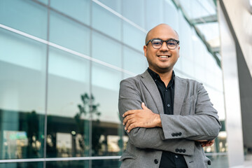 Senior manager business man in suit standing at the buildings downtown. Confident man arms crossed...