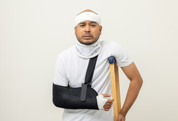 Depressed upset man suffering from pain. Broken arm. Asian man put on plaster bandage cast splint. Male patient wearing sling support arm after accident injury. life insurance and accident