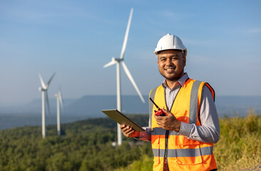 Engineer India man working with tablet at windmill farm Generating electricity clean energy. Wind...