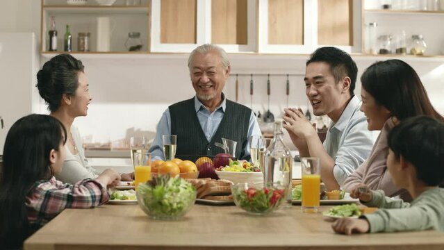 happy three generation asian family eating meal talking chatting conversing at home